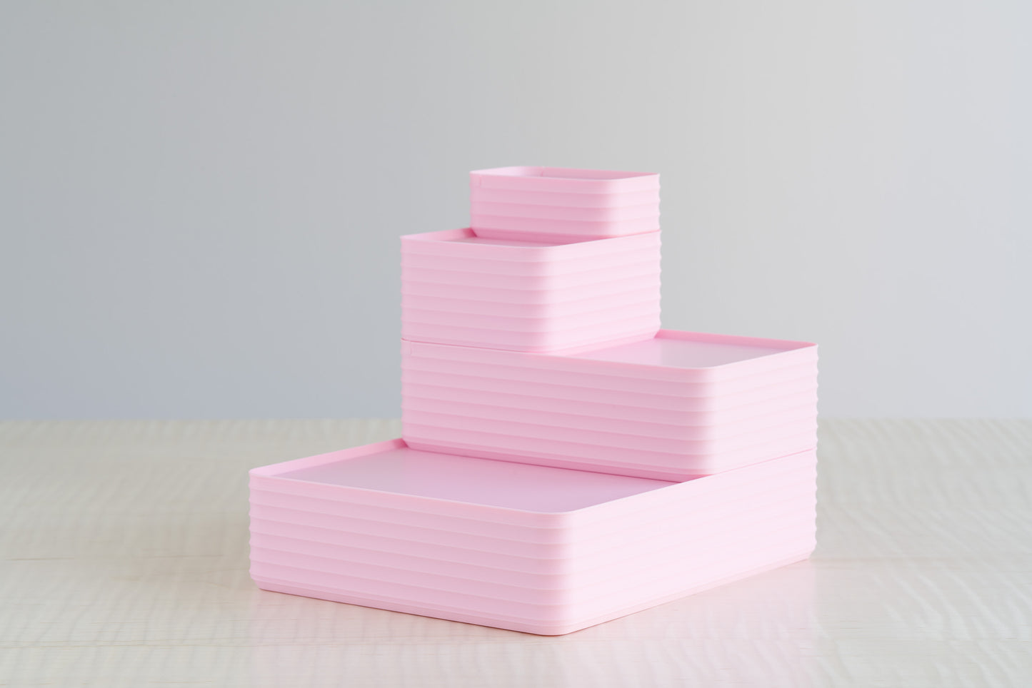 Soft pastel arrangement of Z Co Rib Series boxes in all matte light pink, stacked in a tiered design on a maple table — a sweet and stylish set perfect for baby girl keepsake gift boxes or nursery storage.