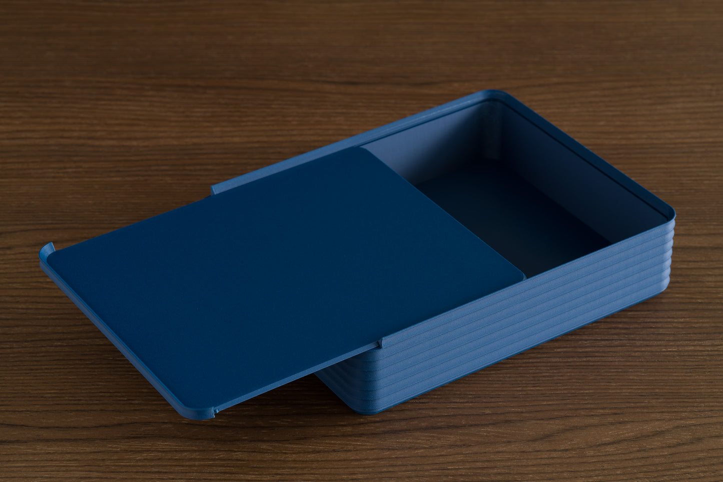 Z Co Rib Series Double-Wide Box in matte dark blue, displayed on walnut surface with lid open. Clean lines and ribbed structure highlight its modern modular storage design.
