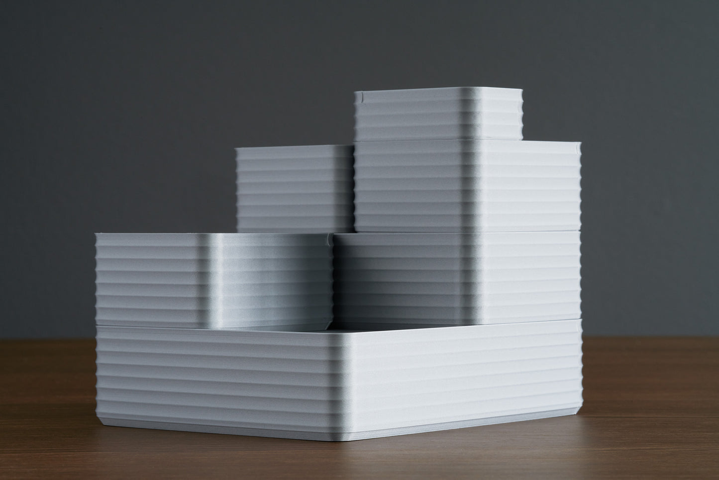 Stacked arrangement of Z Co Rib Series Double-wide, original, small, and mini silver boxes displayed on a walnut surface with a dark gray background.