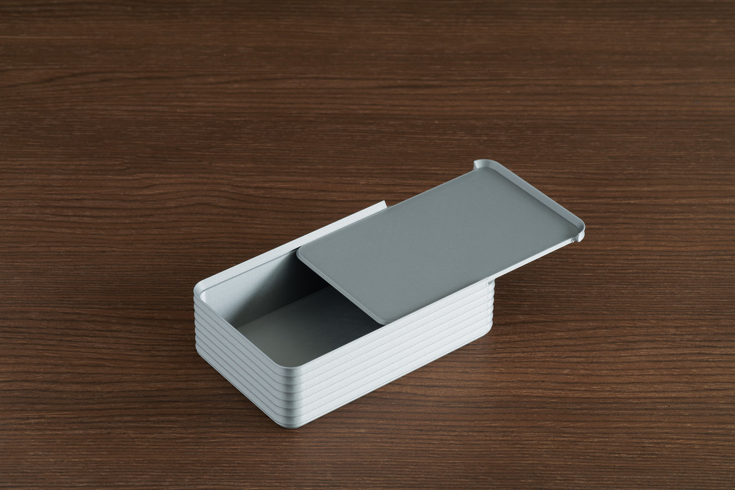 Silver Original Rib Series Box on walnut surface with lid sliding open in reverse direction, revealing spacious interior.