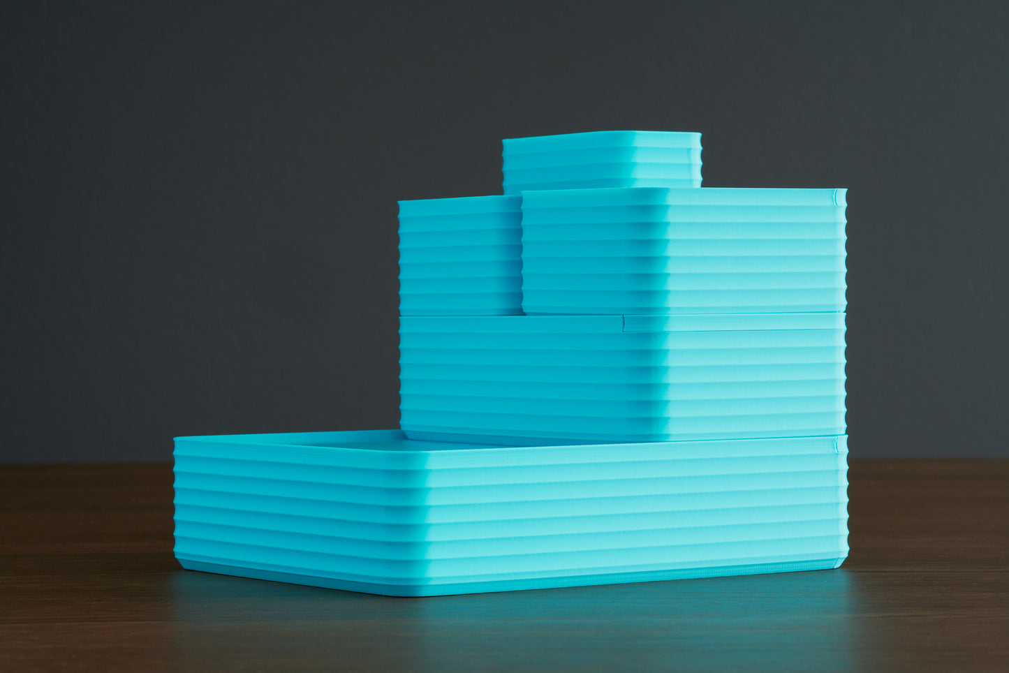 Z Co Rib Series arrangement in all turquoise boxes displayed on a walnut surface. A full stepped arrangement of trays and containers highlights the bold, modern color. Perfect for showcasing the versatility of the collection and inspiring gift card recipients to design their own set.