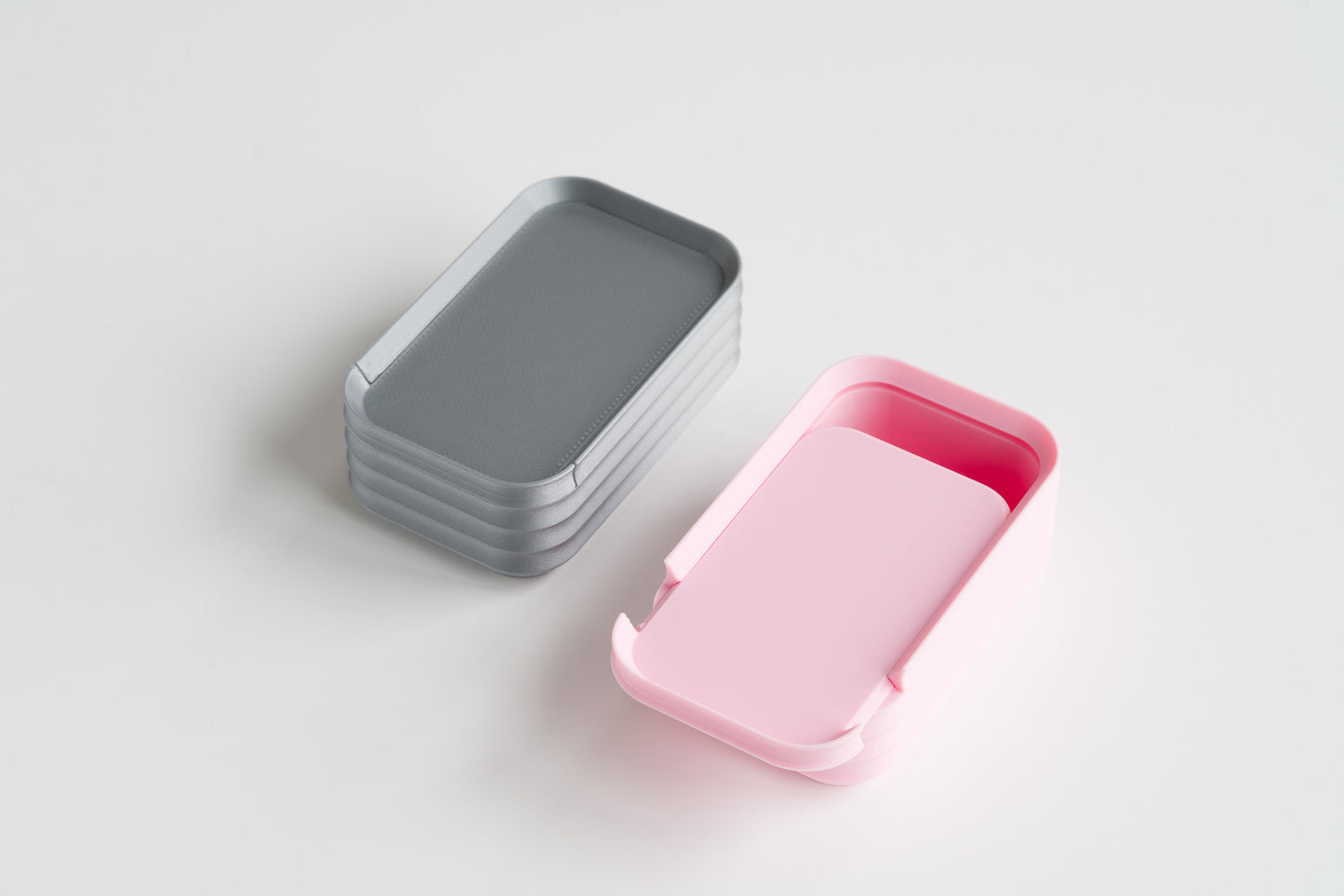 Pair of Z Co mini boxes in silver and pink on white background, one closed and one lid open
