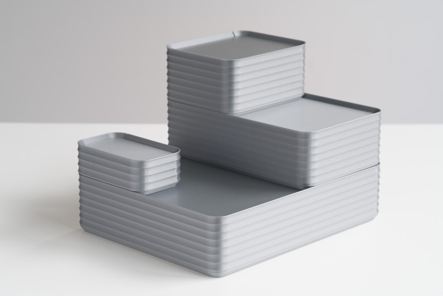 Arrangement of four silver Z Co boxes stacked on white surface