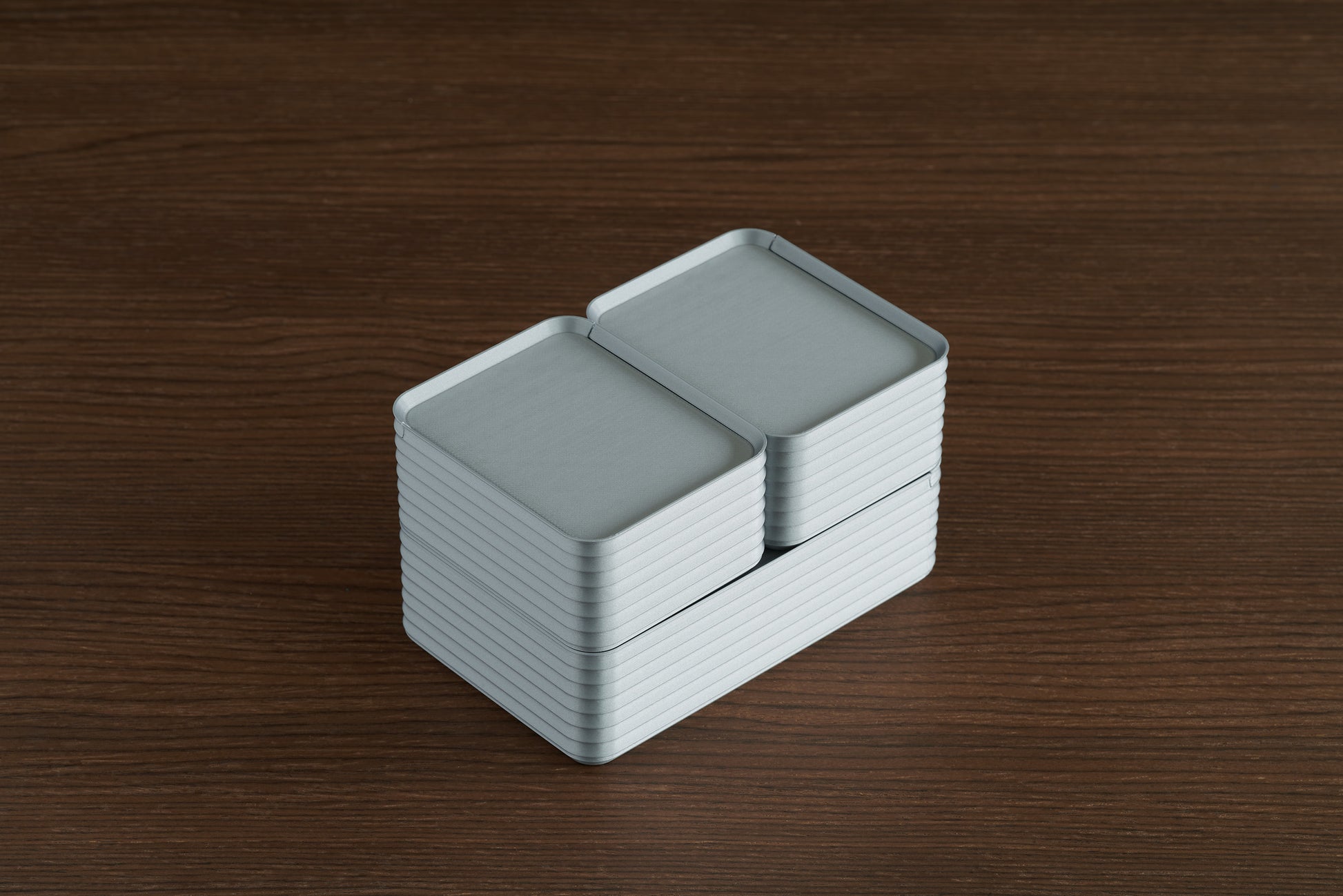Arrangement of silver Z Co ribbed boxes on a walnut table, featuring one original box paired with two small boxes stacked neatly with closed lids.