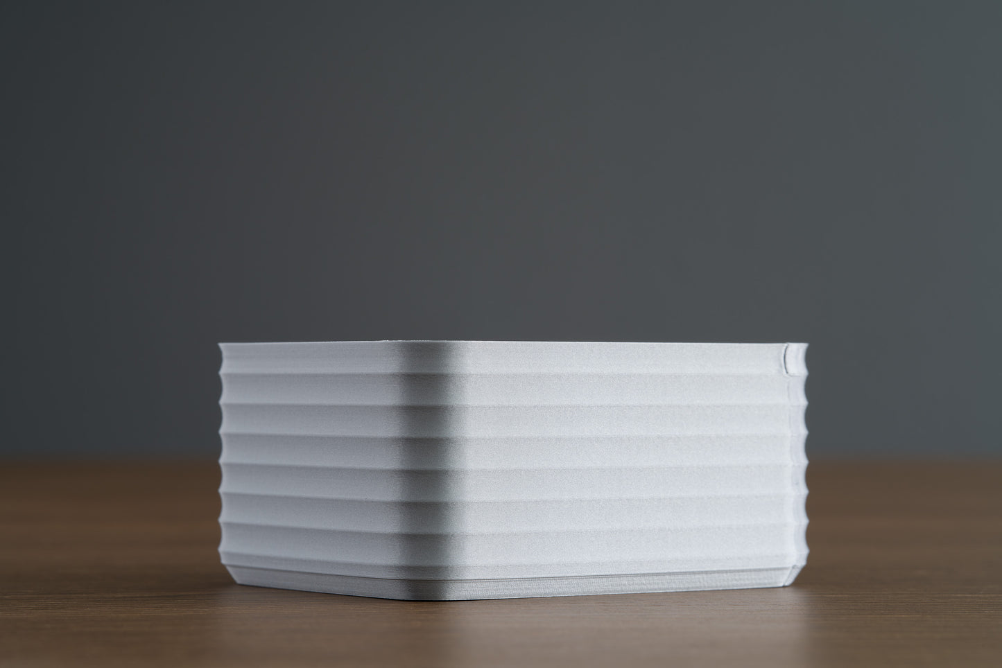 Small Silver Z Co ribbed box rear corner side view, displayed on a walnut surface with dark background.