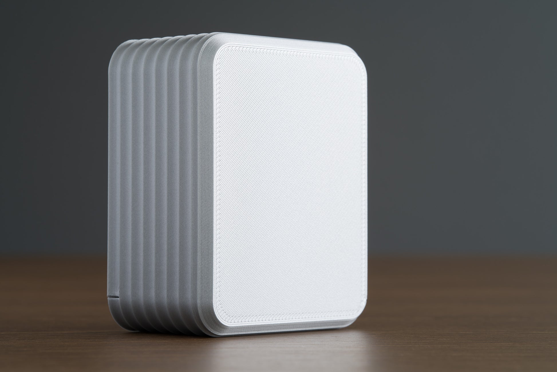 Small Silver Z Co ribbed box standing upright on a walnut surface, bottom view showing textured panel and clean edges