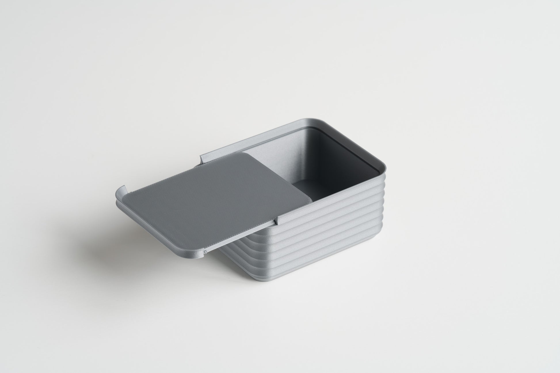 Small Silver Z Co ribbed box open with lid partially slid back, angled orientation on a white background.
