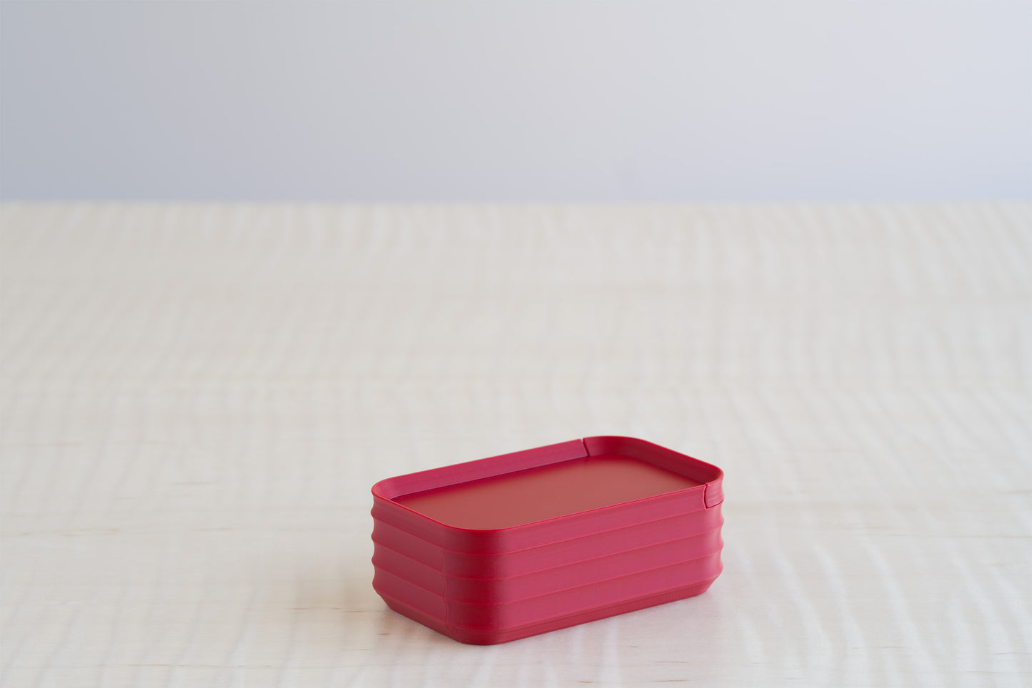 A Z Co Rib Series mini box in matte crimson red, shown individually on a light surface to highlight its bold, modern finish.