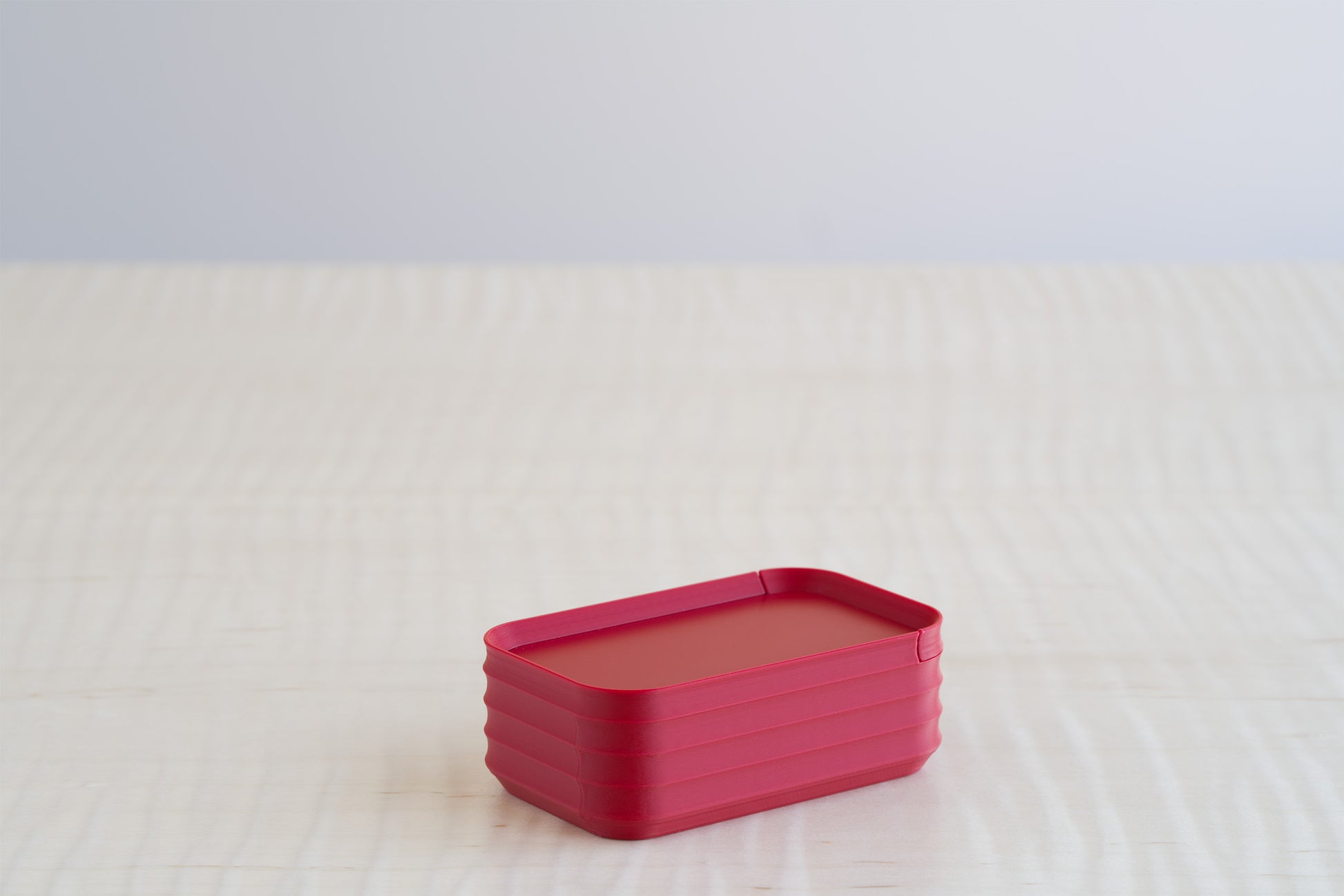 A Z Co Rib Series mini box in matte crimson red, shown individually on a light surface to highlight its bold, modern finish.