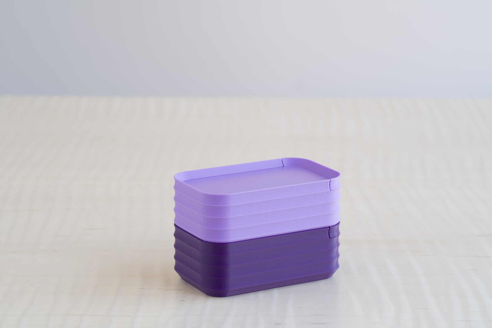 Rib Series Mini Boxes in matte light purple and dark violet, stacked together on a light wood surface to highlight contrasting purple shades.