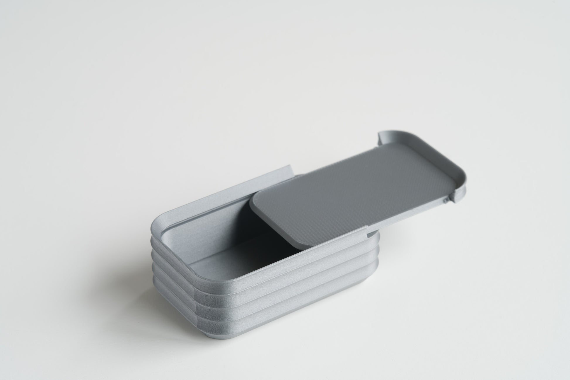 Silver mini box by Z Co with sliding lid halfway open on white background