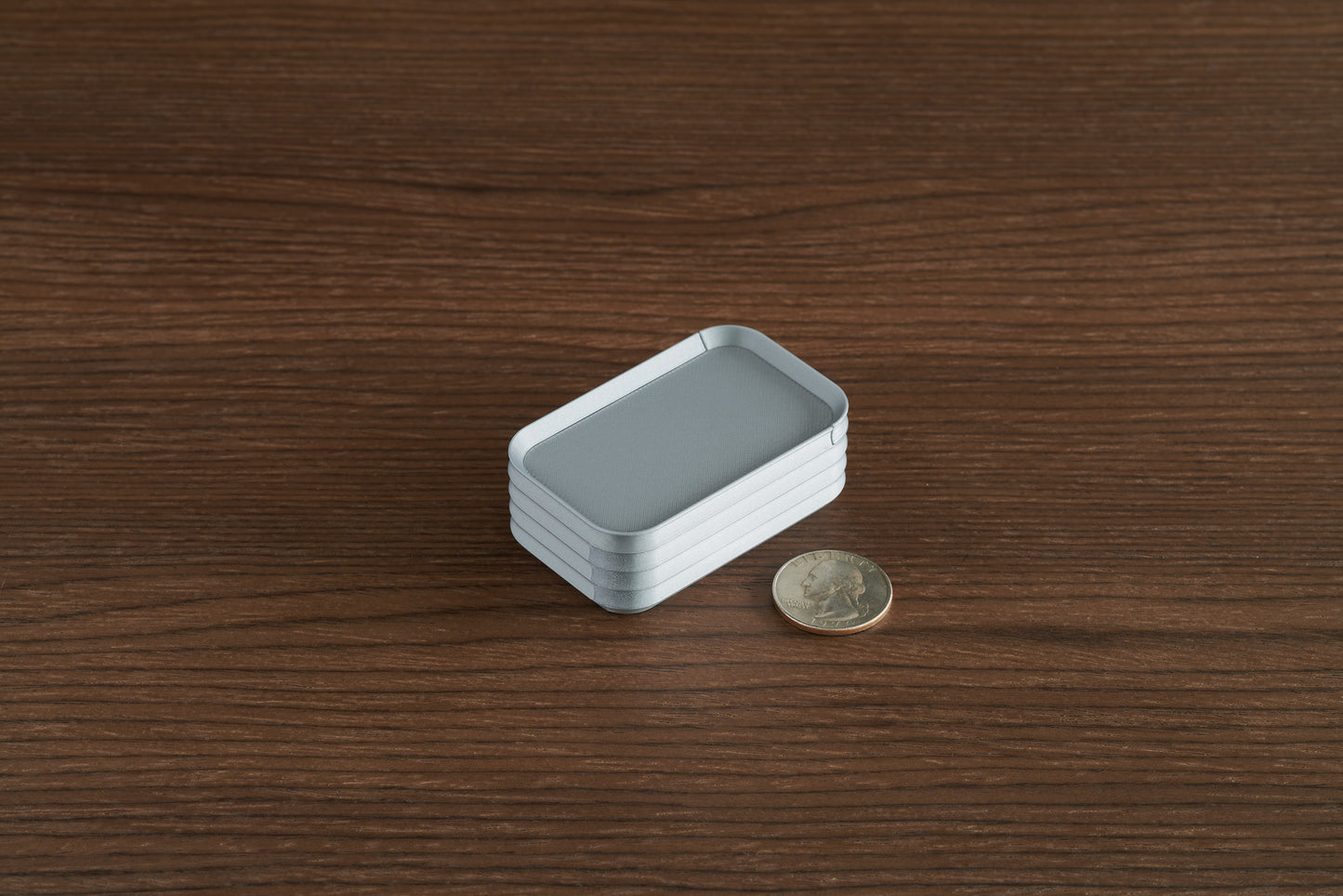 Silver Z Co mini box on walnut surface with quarter for scale