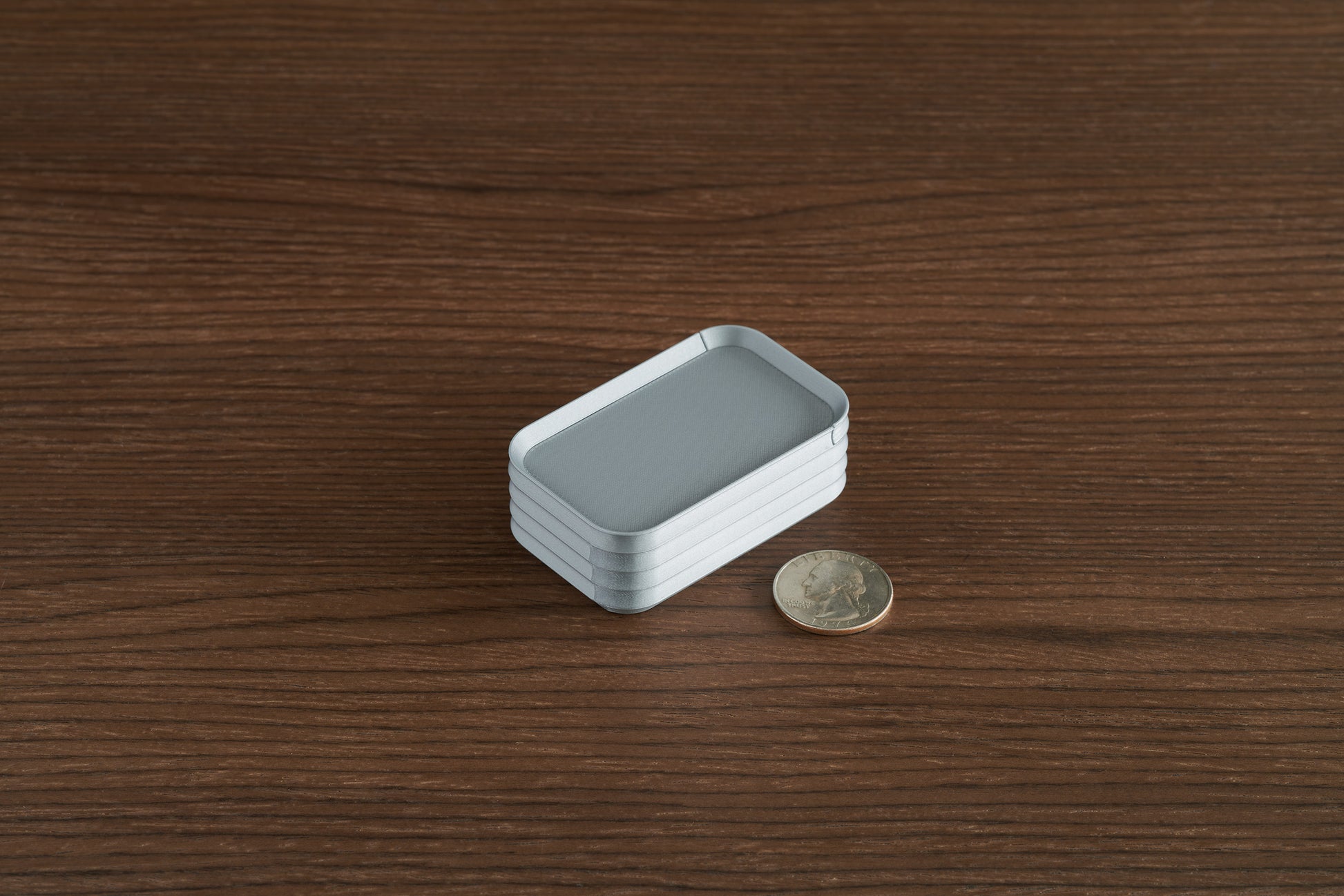 Silver Z Co mini box on walnut surface with quarter for scale